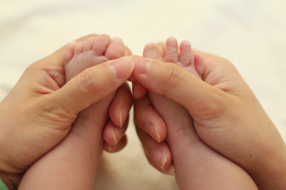 manos acariciando pies de bebes